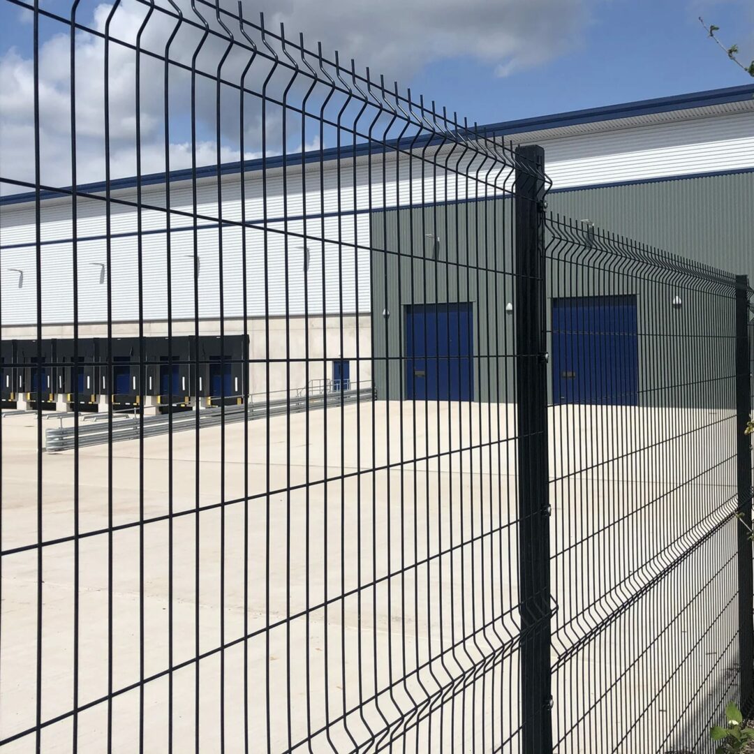 Diamond mesh fencing surrounding an industrial complex, offering security.